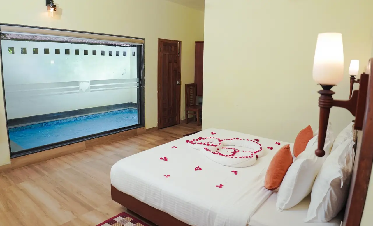 “Spacious luxury bedroom at Indeevara Wayanad with elegant interiors, cozy king-size bed, warm lighting, and scenic nature views.”