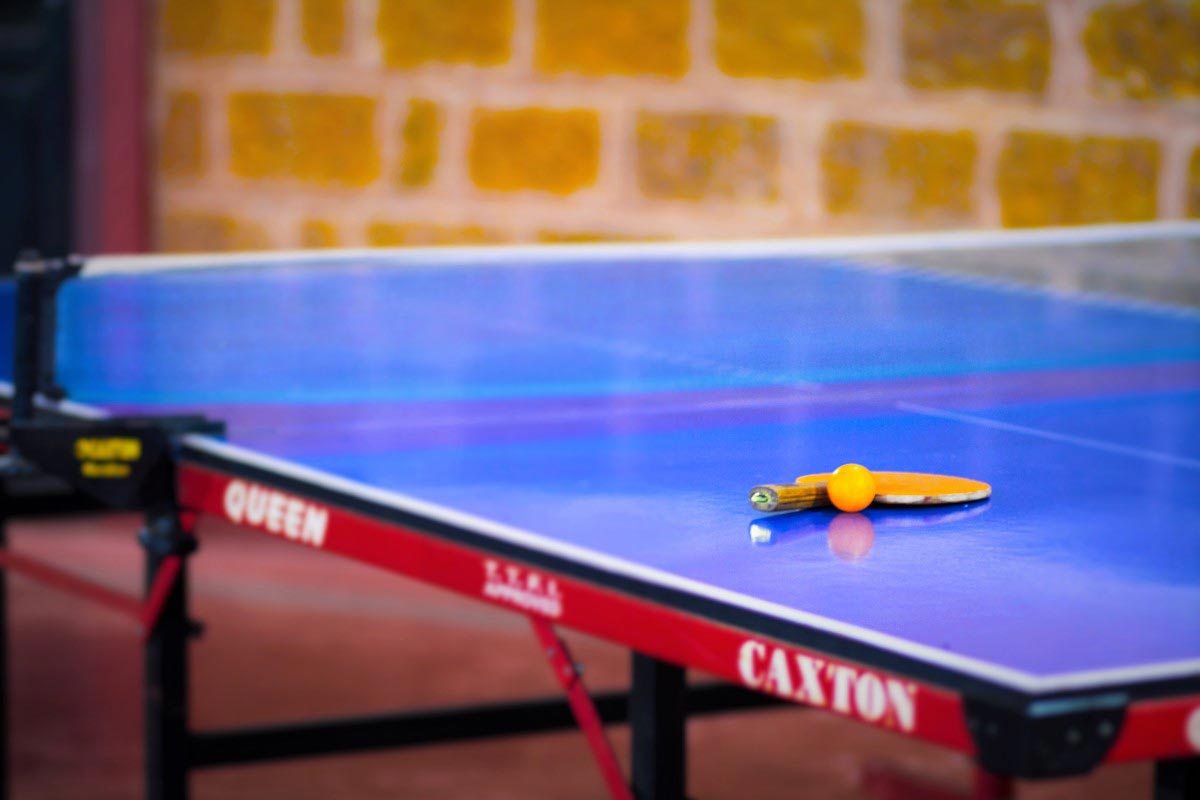 Guests playing table tennis at Misty Woods Resort Coorg, enjoying indoor recreational fun.
