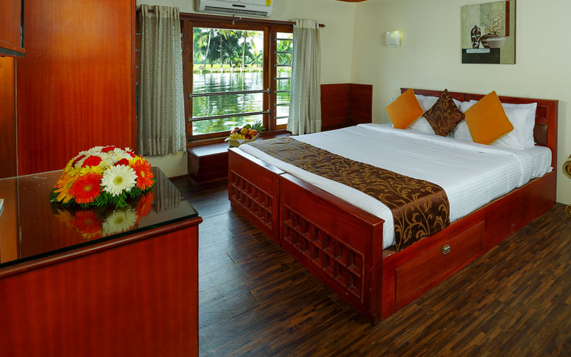 "Cozy and luxurious bedroom on Cruise Land houseboat with elegant interiors and scenic backwater views"