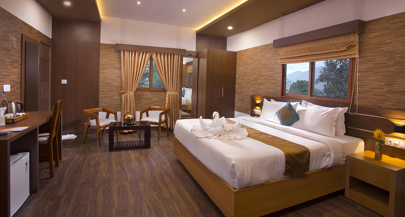 Cozy bedroom with elegant interiors at Dream Catcher Plantation Resort in Munnar featuring a comfortable bed and scenic hill views.