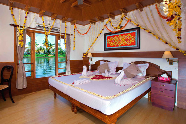 Romantic honeymoon setup on Cruise Land houseboat with floral decorations, candlelight, and cozy seating"