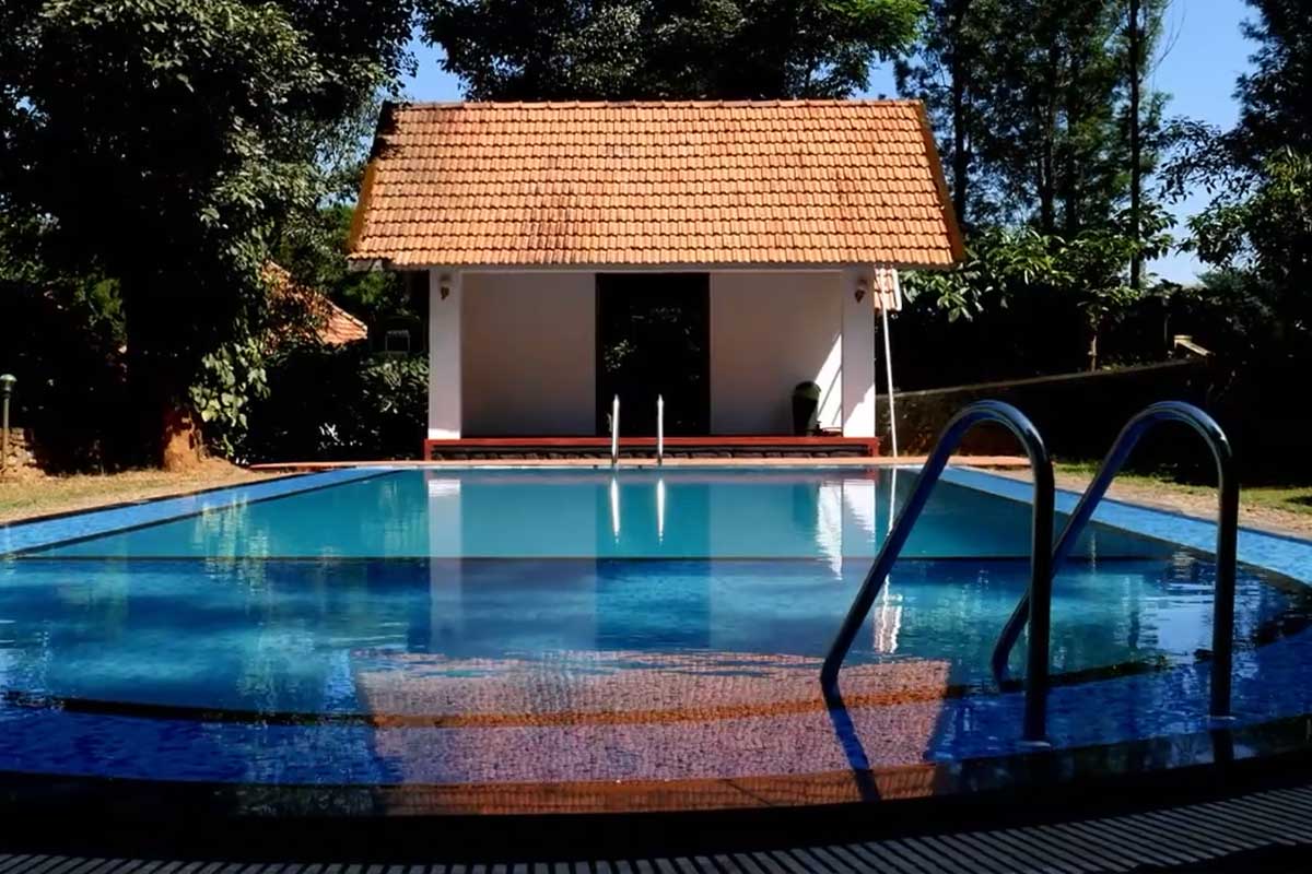 Open-air swimming pool at Misty Woods Resort surrounded by lush greenery