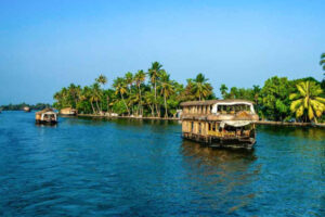 Traditional houseboat in Alleppey cruising through calm backwaters surrounded by coconut trees and village scenery