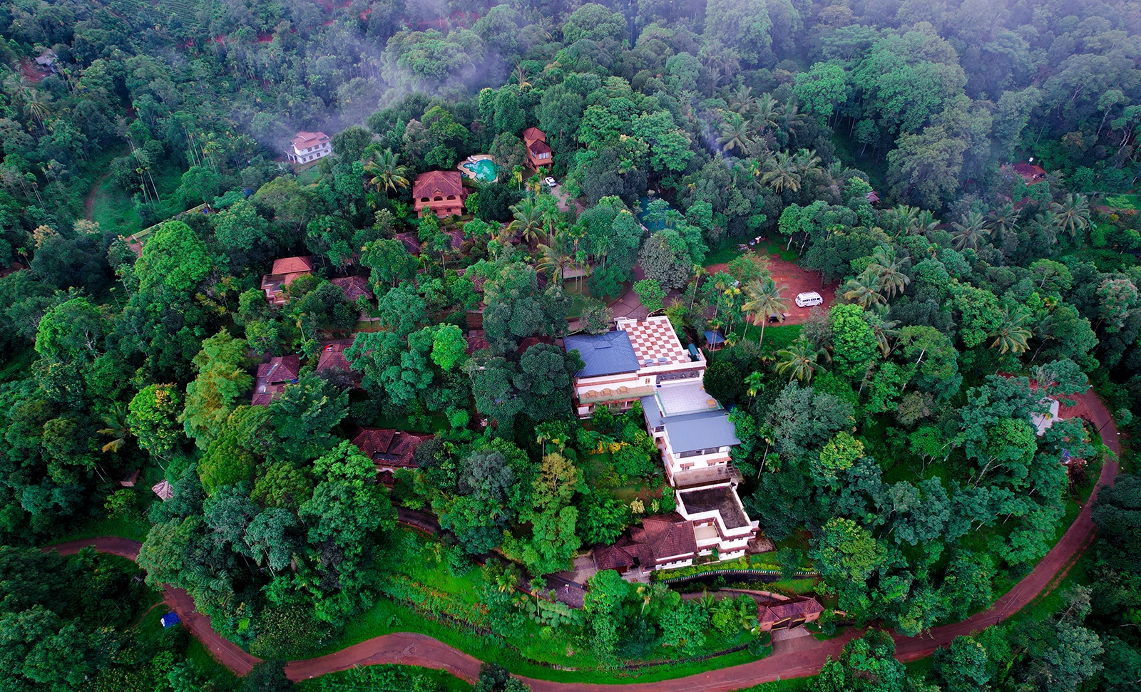 Scenic landscape of Wayanad featuring mist-covered hills, lush green forests, waterfalls, tea plantations, and serene natural beauty in Kerala.