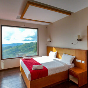 Bedroom with hill view at Warmth Hill Crest Kodaikanal featuring cozy interiors and scenic valley views