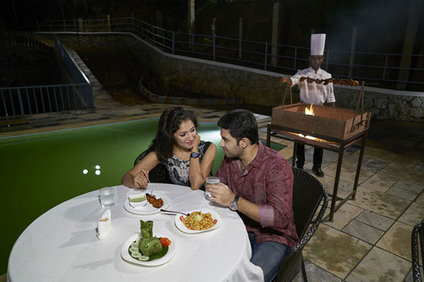 Romantic moments at Southern Panorama Indriya in Munnar with a couple enjoying a candlelight dinner surrounded by scenic hills and a peaceful ambiance.