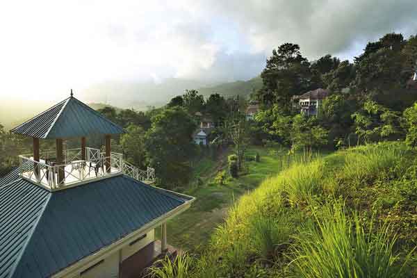 Scenic hill view from Southern Panorama Indriya Munnar overlooking misty mountains, lush green valleys, and rolling tea plantations.