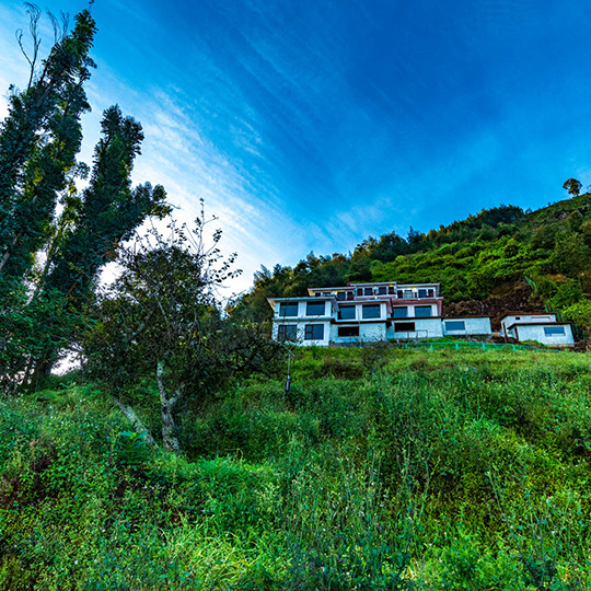 Warmth Hill Crest in Kodaikanal situated in a picturesque location, surrounded by rolling hills, lush greenery, and breathtaking valley views that showcase the beauty of the hill station.