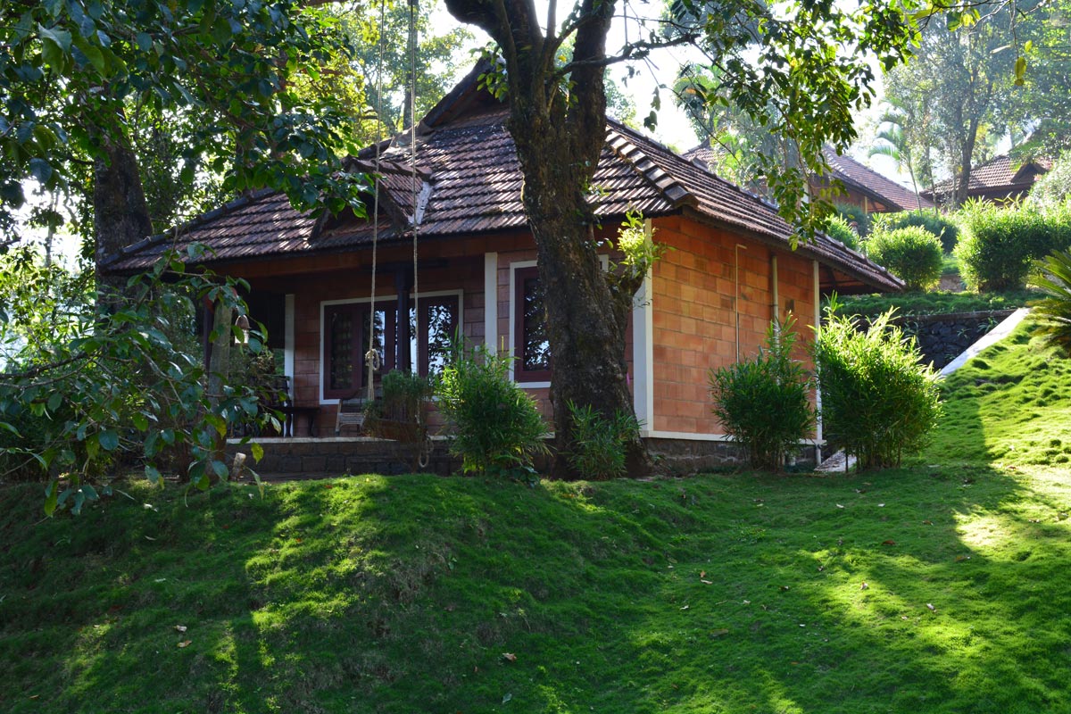 Fairy Tale Cottage at Misty Woods Coorg Resorts with cozy interiors, fireplace, and scenic views of lush forests and waterfalls.